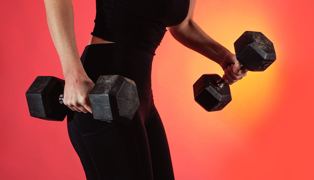 person-dressed-in-black-holds-two-weights-in-each-hand